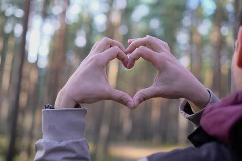Mans hands folded into a heart symbolizing love and feelings against the Stock Photos
