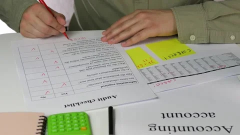 A mans hands in a formal shirt work with an audit checklist marked with red Stock Footage 318580908