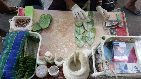 Man’s hands in gloves put spices and betel on traditional chewing tobacco leaves Vídeos de archivo 77838489
