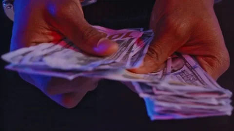 Man's hands in handcuffs hold a wad of money. hands with handcuffs holding Stock-Footage 336260477