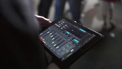 Man's hands hold black tablet pc with light control program at concert. The Stock Footage 148361797