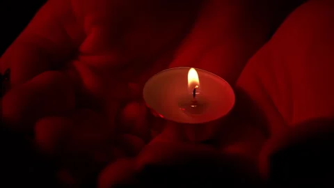 Man's Hands Hold a Candle in Red Lighting Dark Close-up Stock Footage 243670184