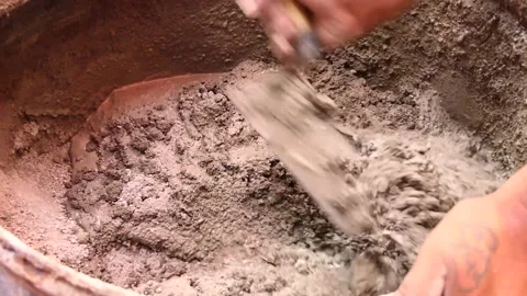 Man's hands hold a shovel while making a mixture of cement, sand, and water. Video stock 153450068