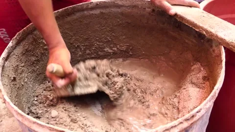 Man's hands hold a shovel while making a mixture of cement, sand, and water. Stock Footage 153450070