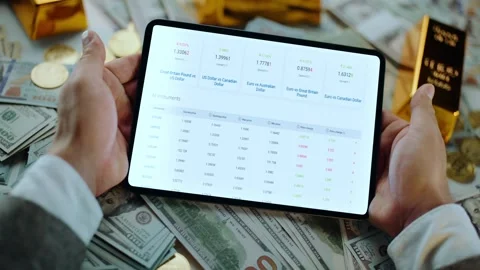 A man's hands hold a tablet displaying stock market data, surrounded by us .. Stock Footage 337542560