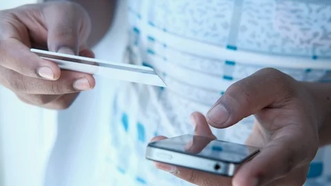 Man's hands holding a credit card using smart phone for online shopping Stock Footage