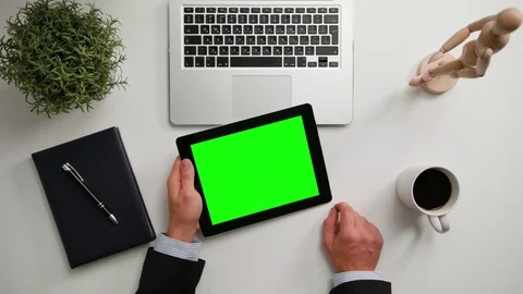A Man's Hands Holding an i-Pad with a Green Screen Stock Footage 83724944