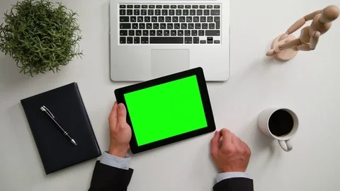 A Man's Hands Holding an i-Pad with a Green Screen Stock Footage 83725312