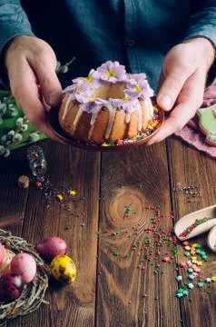 Man's hands holding traditional Easter cake decorated with flowers Stock Photos