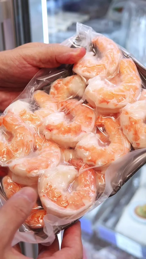 Man's hands holding vacuum-packed boiled prawn in the grocery store. Stock Footage 324874149