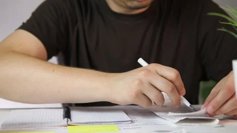 A mans hands at a home desk work through a stack of receipts, meticulously Stock Footage 318580851