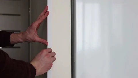 Mans hands installing protective decorative corner on the wall in apartment. Stock Footage 169240043