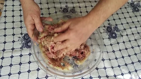 The man's hands interfere with the ground meat and onions. Stock Footage 137132176