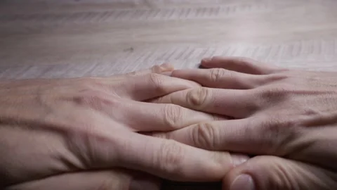 Mans Hands Interlocking Fingers in Contemplation on a Wooden Desk Stock Footage 328658850