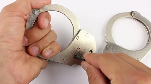 The man's hands with the key opening the lock in handcuffs Stockbeeldmateriaal 24615446