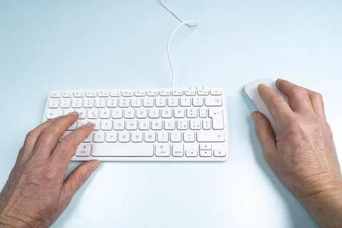 A man's hands on a keyboard and mouse Stock Photos