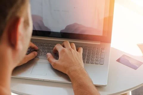 Man's hands on the keyboard of the laptop close-up. Stock Photos