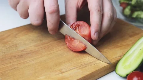 Man's hands with knife cutting tomato for fresh salat. Video stock 151320792