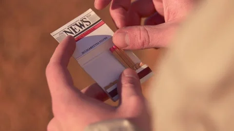A man's hands light a match from an old pack of matches, in Spain Stock Footage 208730222