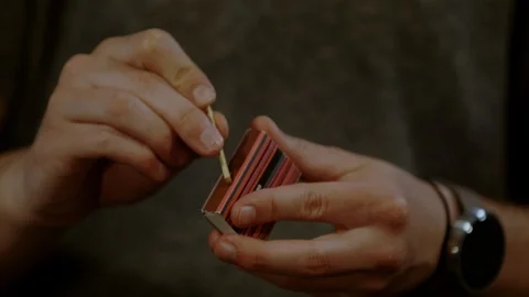 Man's hands lighting a match, Ultra Slow Motion Stock Footage 86584045