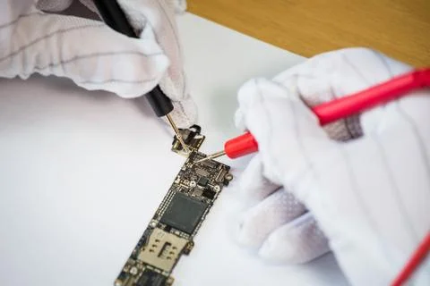 Man's hands measuring voltage on the small gadget plate, repair service con.. Foto stock