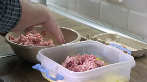 Mans hands mixes minced meat with chopped potatoes to prepare cutlets at the Stock Footage 165312057