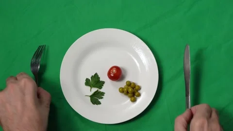 A man's hands move closer to the plate of meager food. Portion control. The 스톡 동영상 167966186