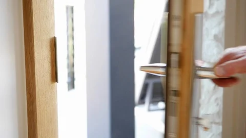A man's hands open and close wood, exterior glass door with new stainless hardwa Stock Footage 98013740