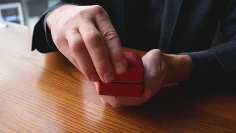 A man's hands open a box with a wedding ring Stock Footage 169473401