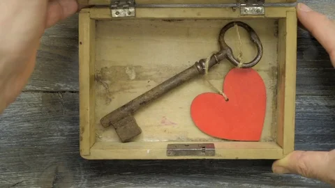 A man's hands open a box in which there is a key and a red heart Stock Footage 74513949