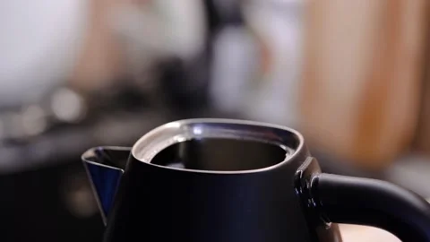 Man's hands open the electric kettle and water pours into the kettle Vidéo 230930885