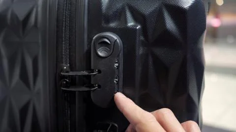 Man's hands open suitcase combination lock on the suitcase. Stock Photos
