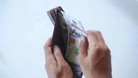 The man's hands open a wallet filled with one hundred dollar bills Stock Footage 322159506