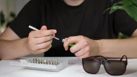 A mans hands opening a box with a screwdriver and bits, taking out a screwdriver 스톡 동영상 313857901