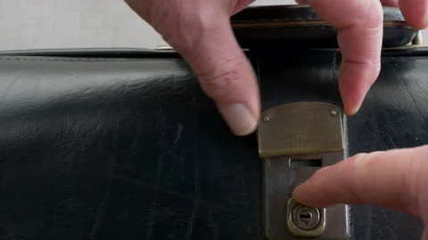 Man's hands opening an old leather briefcase. Stock Footage 140452779