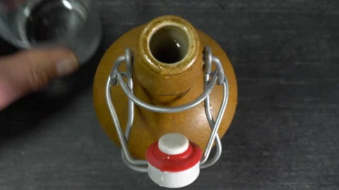 Mans hands opening a swing top bottle then pulling a glass near. Stock Footage 176922453