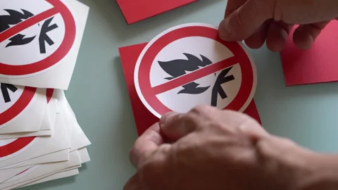 Man's hands pasting "no fire" sign on a red  plastic board. Stock Footage 284038702