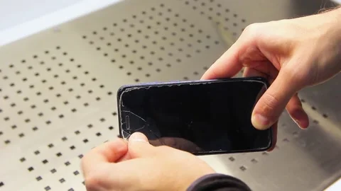 Man's hands peel off the damaged protective glass from the screen of a mobile Stock Footage 223363500
