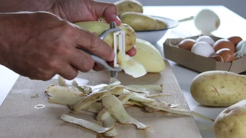 Man's hands peeling potatoes to prepare a Spanish omelette. Close up. Stock Footage 197118480