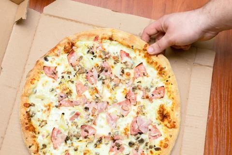 Man's hands picking slice of Carbonara pizza with cheese, bacon, onion, moz.. Stock Photos