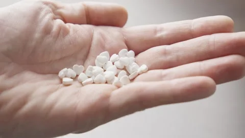 Man's hands with pills going to take some medicine. Heart shape pills. Stock Footage 304287159
