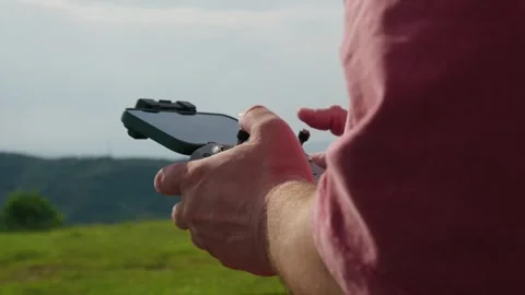 Man's Hands Piloting a Drone with a Remote Controller Outdoors Stock Footage 335768597