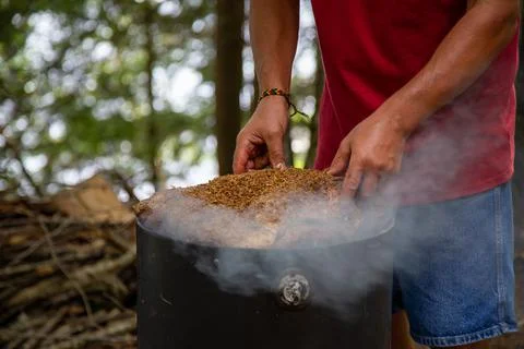 Mans hands placing a large beef brisket on a smoker Stock Photos