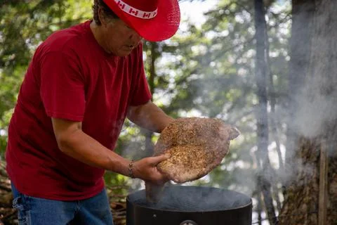 Mans hands placing a large beef brisket on a smoker Stock Photos