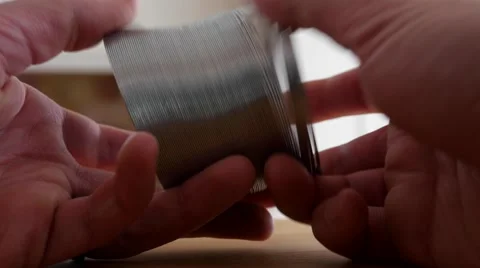 A mans hands play with a slinky Stock Footage 58848035