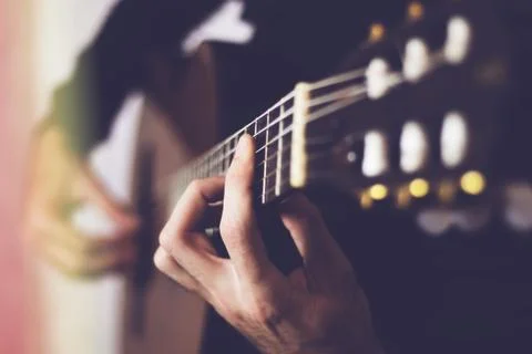 Man's hands playing classical guitar, close-up Stock Photos