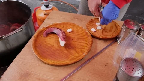 A man's hands preparing a portion of the dish the traditional Galician octopu Stock-Footage 124709360