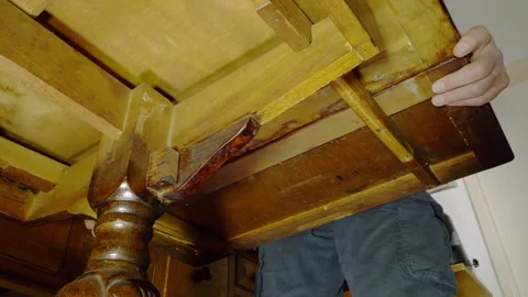 A man’s hands pulling out the extra leaf from an extending dining table. Video stock 300871346