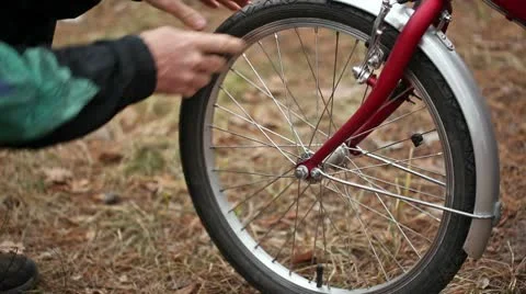 Man's hands pump up a bicycle wheel Stockbeeldmateriaal 10325157
