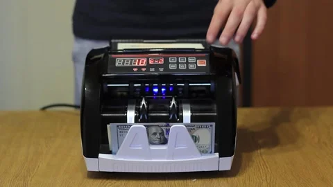 Man's hands put dollars in electronic money counter. electronic money counter Stock-Footage 132067674